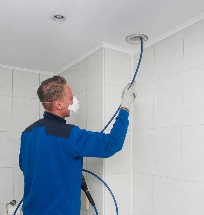 Monteur van Centraal Ventilatie reinigt een ventilatiesysteem